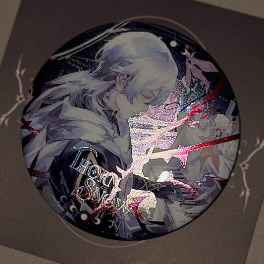 Angled view of Sunday 75mm badge showing glossy finish and vibrant double-holographic reflection under light, winter-themed HSR merch.