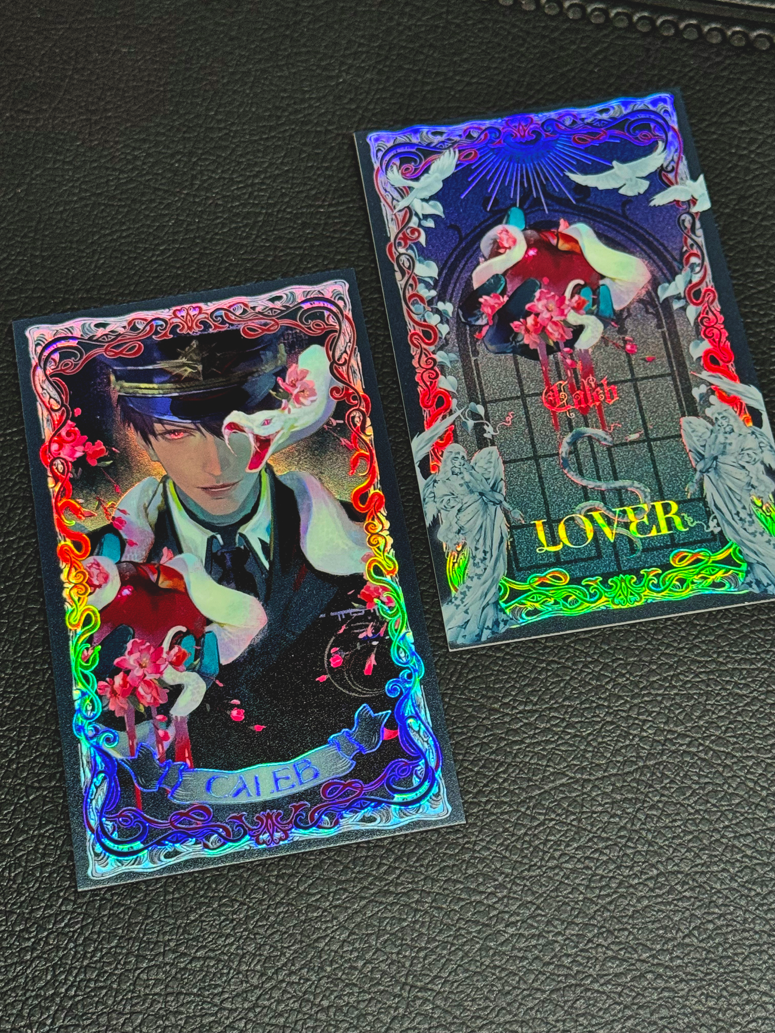 Physical display of Caleb Forbidden Apple tarot card showing the reflective finish and matching artwork by AO Treehouse.